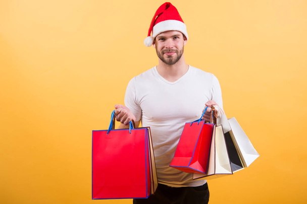 man in santa hat hold christmas present. online christmas shopping. Happy new year. delivery christmas gifts. happy santa man on yellow background. The morning before Xmas. Merry Christmas - Fotoğraf, Görsel