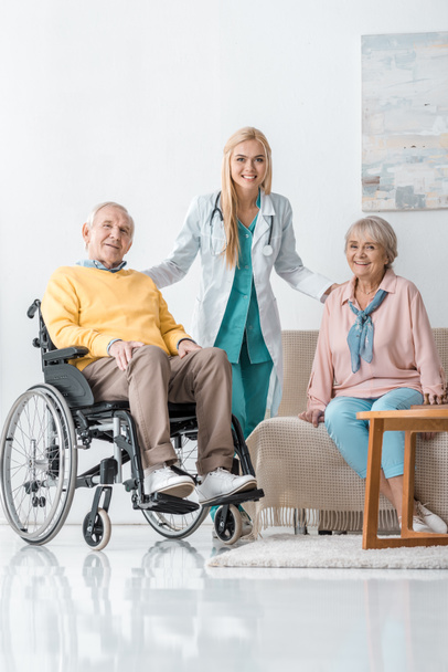 young cheerful female doctor talking to senior people at nursing home - Φωτογραφία, εικόνα