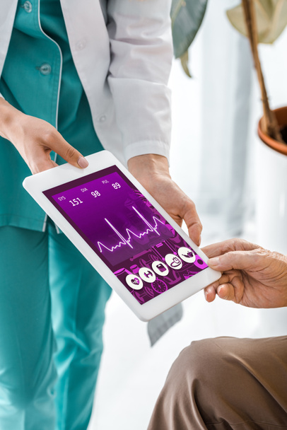 az orvos és a beteg kezei cardiogram digitális tabletta képernyő közelről - Fotó, kép