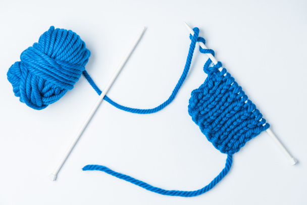 白い背景の青い糸と編み針のトップ ビュー - 写真・画像