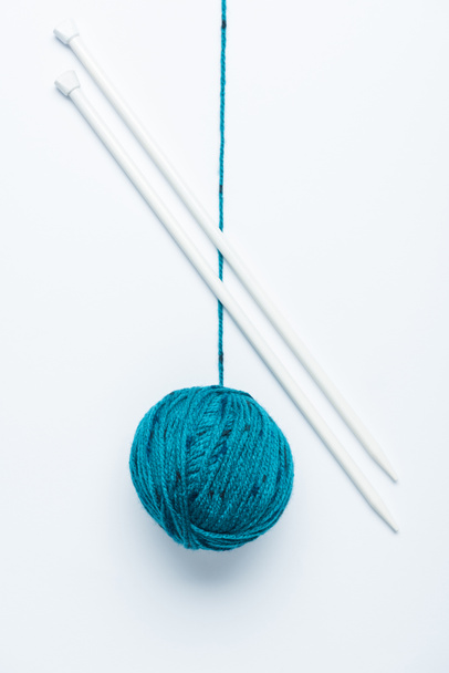ylhäältä näkymä sininen lanka pallo ja neulepuikot valkoisella pohjalla
 - Valokuva, kuva