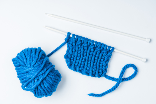 vue de dessus des fils bleus et des aiguilles à tricoter sur fond blanc
 - Photo, image