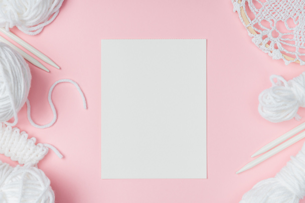 白い糸、編み針、ピンクの背景の空白の紙とフラット レイアウト - 写真・画像