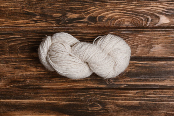 pohled shora na zámotek bílé příze pro pletení na dřevěný povrch - Fotografie, Obrázek
