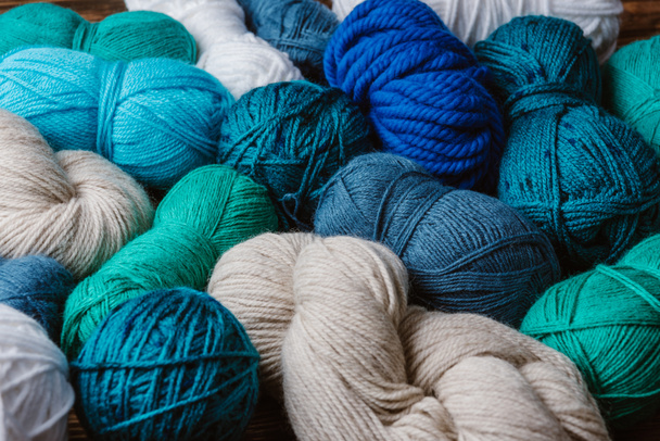 close up view of white, blue and green yarn for knitting as backdrop - 写真・画像