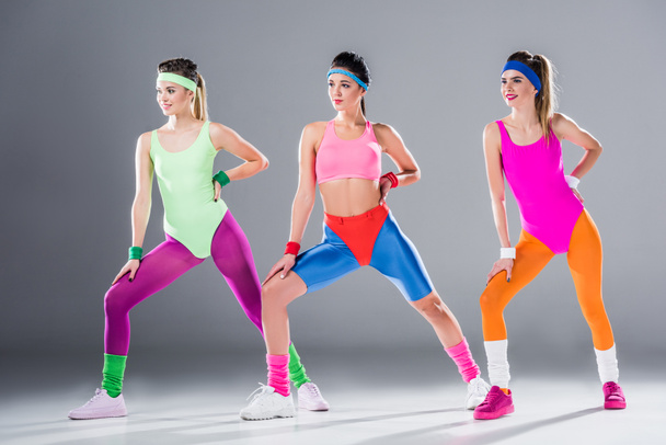 beautiful sporty young women training at aerobics workout on grey - Zdjęcie, obraz