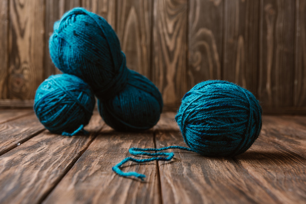 vista de perto de fios azuis para tricô dispostos em superfície de madeira
 - Foto, Imagem