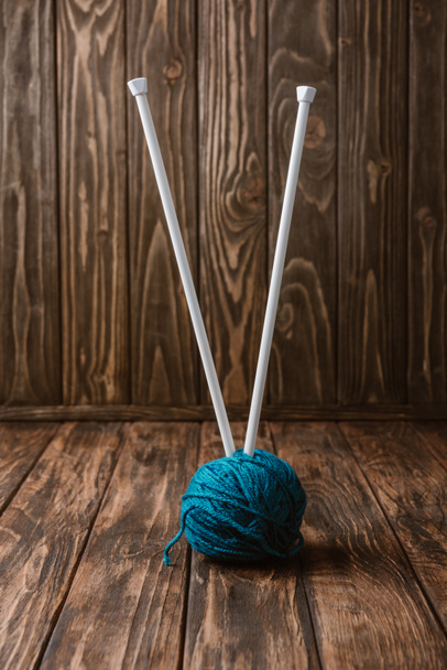 vue rapprochée de la boule de fil bleu et des aiguilles à tricoter sur la table en bois
 - Photo, image