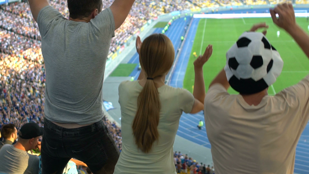 Friends happy with goal scored jump up at stadium, cheering for favorite team - Filmmaterial, Video