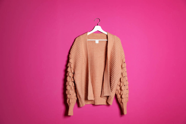 Hanger with stylish sweater on color background - Foto, imagen