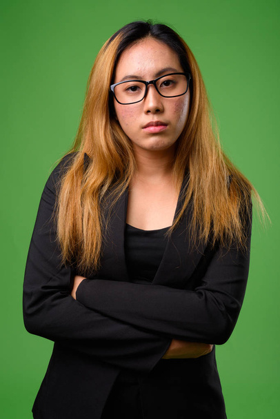 緑を背景にした若いアジア人実業家の肖像 - 写真・画像