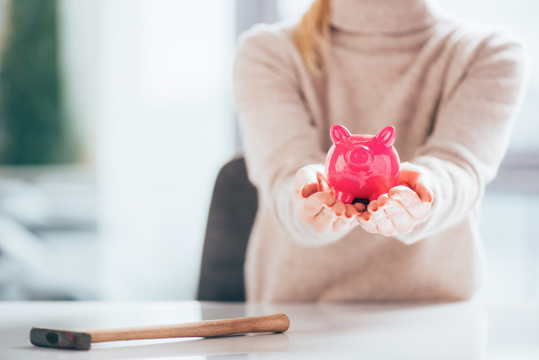 cropped shot of woman holding pink piggy bank - Fotó, kép
