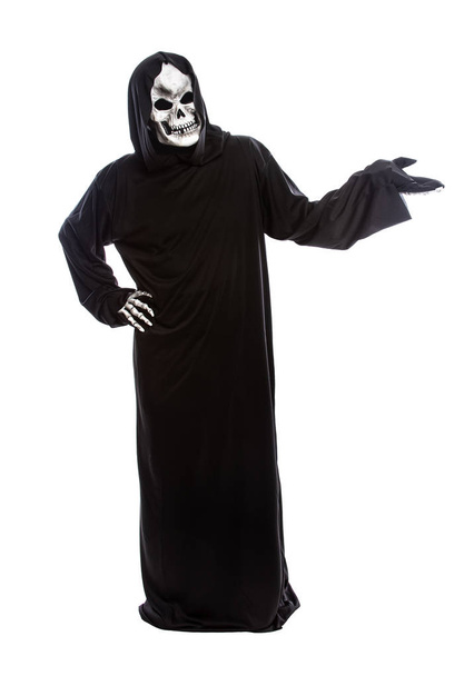 Halloween-Kostüm eines skelettierten Sensenmannes in einem schwarzen Gewand auf weißem Hintergrund, der etwas präsentiert oder bewirbt - Foto, Bild