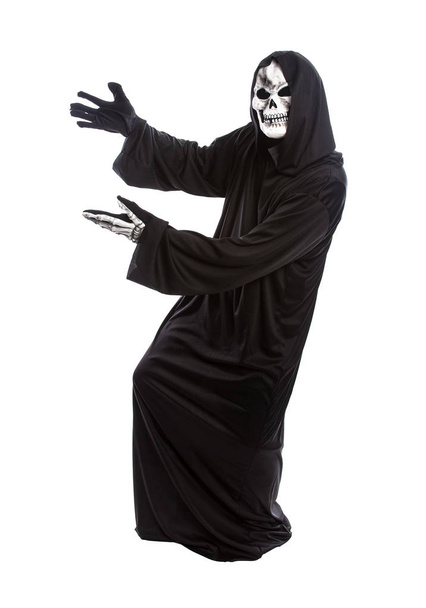 Traje de Halloween de um ceifeiro sombrio esqueleto vestindo um manto preto em um fundo branco apresentando ou anunciando algo
 - Foto, Imagem