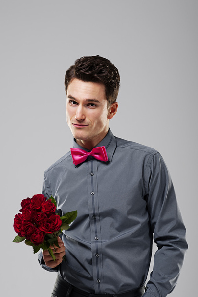 Handsome man holding red roses - Foto, immagini