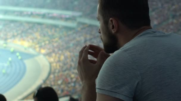Male supporter watching sport game at stadium, concentrated and agitated, worry - Záběry, video
