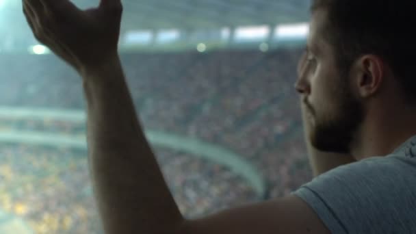 Sport fan clapping hands, watching game at stadium, supporting favorite player - Séquence, vidéo