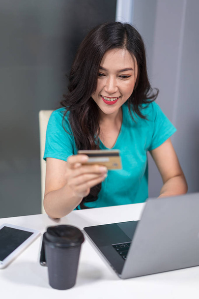 šťastná žena pomocí přenosného počítače pro online nákupy s kreditní kartou - Fotografie, Obrázek