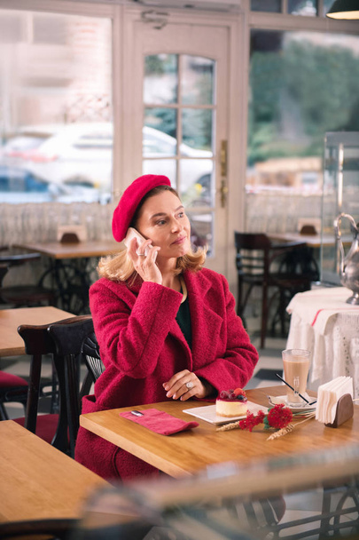 Elegant mature lady having dessert and drinking coffee in bakery - Foto, Bild
