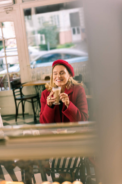 Beautiful lady feeling relaxed drinking some coffee during break - 写真・画像