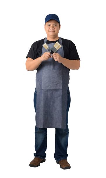 Full body portrait of a worker man or Serviceman in Black shirt and apron is holding paint brush isolated on white background clipping path. Hand-made, DIY concept - Photo, Image