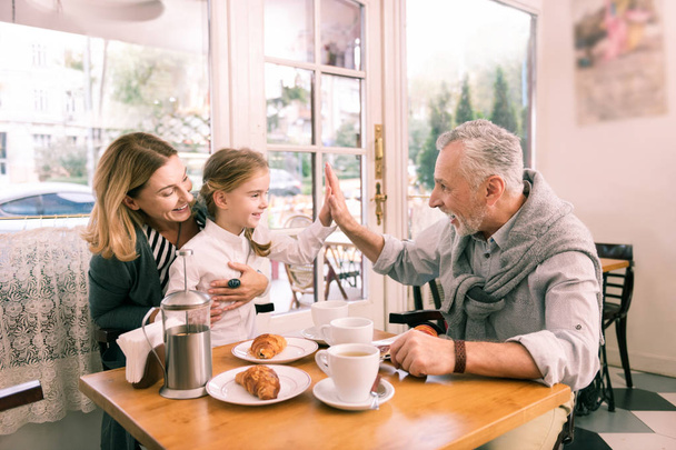 Modern grandfather giving high five his cute little granddaughter - Photo, image