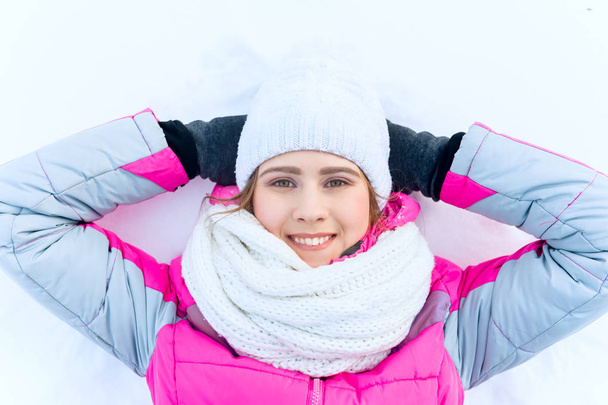 Outdoor portrait  young happy smiling girl lying in the snow - Foto, immagini