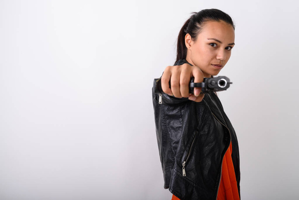 Studio záběr mladé asijské ženy míření pistole na kameru před - Fotografie, Obrázek