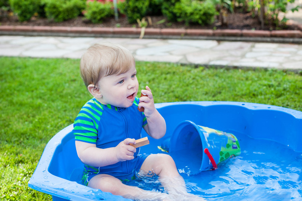 Nyáron víz játszó szőke kisgyermek, kisfiú. - Fotó, kép