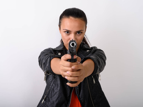 Κοντινό πλάνο του νεαρή γυναίκα της Ασίας στοχεύοντας handgun στην κάμερα με δύο - Φωτογραφία, εικόνα