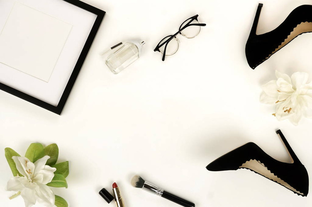 Flat lay, top view female black shoes with heels, accessories and make up cosmetics. bag, headscarf, glasses, lipstick, mascara, powder, brush, parfume on a white background.  Copy space. - 写真・画像