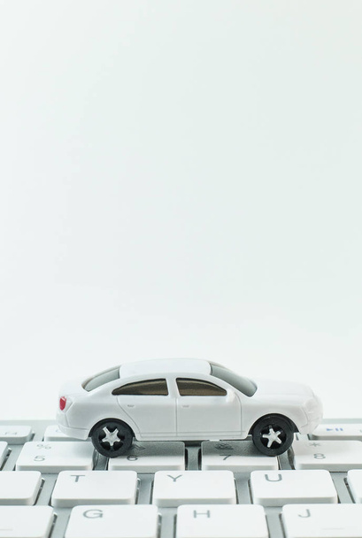 witte speelgoedauto op toetsenbord computer close-up achtergrond afbeelding. - Foto, afbeelding
