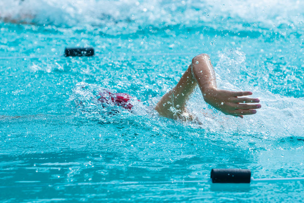 Young swimmer doing freestyle stroke swim lap at a local pool - Fotoğraf, Görsel
