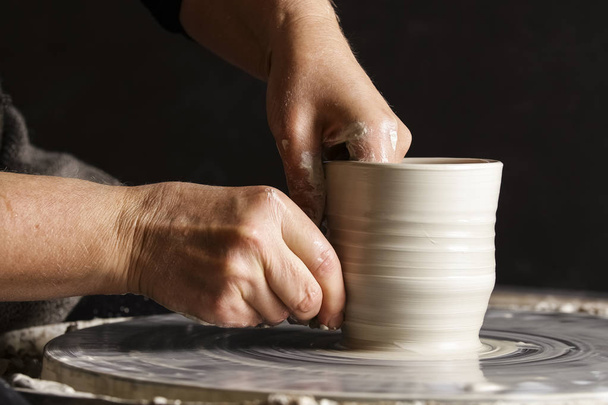 Professional female potter working in workshop, studio. Close up shot of potter's hands. Handmade, small business, crafting work concept - Foto, imagen