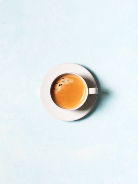 Top view of cup of coffee espresso on blue pastel background - Foto, afbeelding