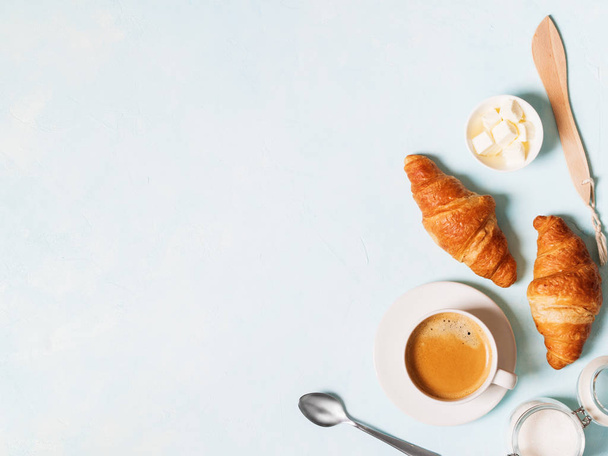Cup of espresso with capsules, croissants and butter on blue pastel background  - Foto, Bild