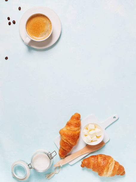 Cup of espresso with capsules, croissants, coffee beans and butter on blue pastel background  - Fotografie, Obrázek