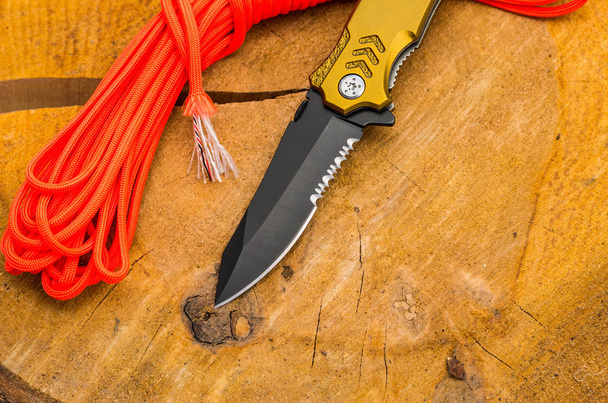 Lame d'un couteau avec une scie pour couper les cordes et une ceinture de sécurité. Corde orange
. - Photo, image