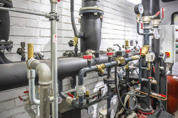 Sistema de calefacción de casas con muchos tubos de acero, manómetros y tubos metálicos y equipo de control automatizado
 - Foto, imagen