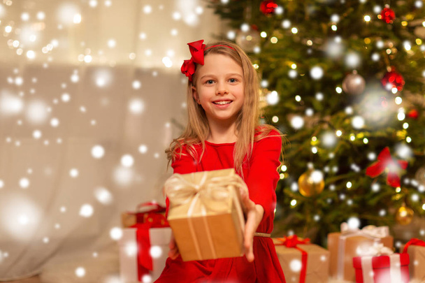smiling girl with christmas gift at home - Foto, immagini