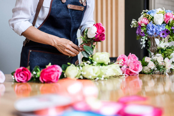 Arranging artificial flowers vest decoration at home, Young woman florist work making organizing diy artificial flower, craft and hand made concept. - Photo, image