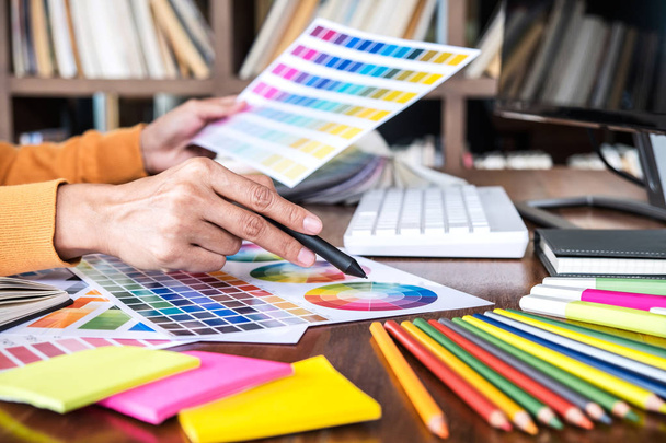 İş yerinde iş araçları ve aksesuarlarıyla renk seçimi ve grafik tableti üzerinde çalışan kadın yaratıcı grafik tasarımcı resmi. - Fotoğraf, Görsel