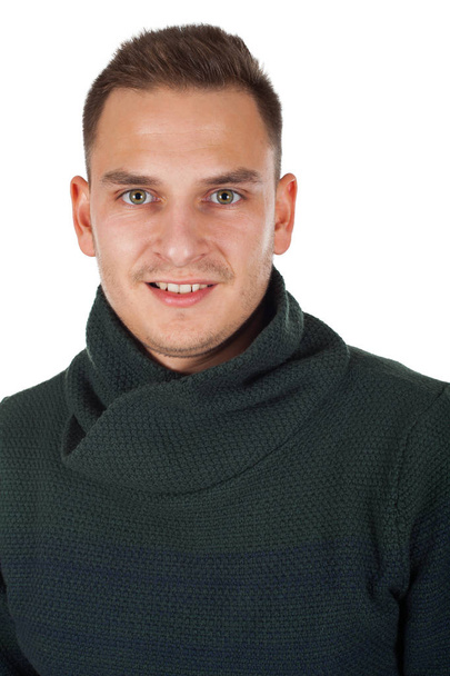 Hombre joven guapo con un suéter de punto caliente está mirando a la cámara en un fondo aislado
 - Foto, imagen