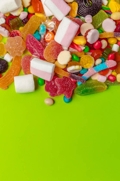 Colorful candies on green background - Foto, imagen