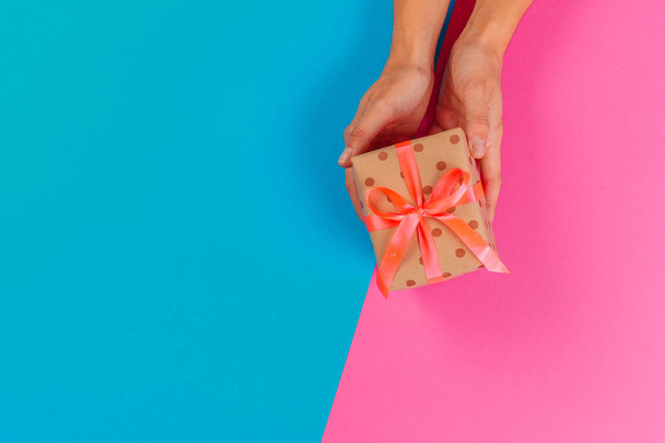 Woman holding gift box on color background - Valokuva, kuva