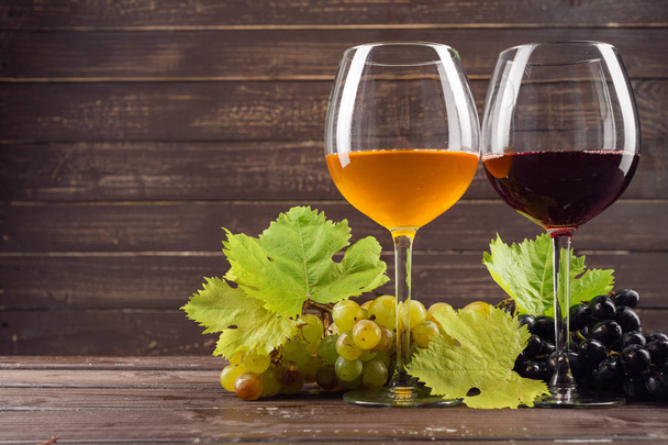 винний келих і купа винограду на дерев'яному столі
 - Фото, зображення