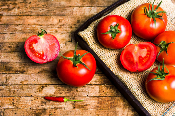 Tomatoes on a rustic wooden table top view - Photo, Image