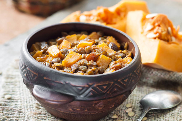 Homemade spicy curry with green lentils, pumpkin and raisins in rustic ceramic bowl - Photo, Image