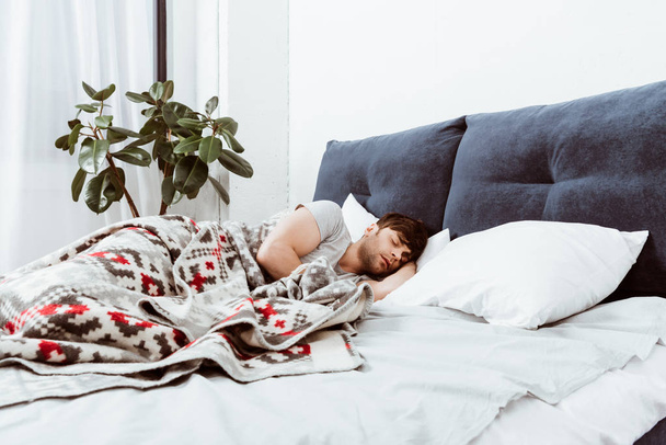 szelektív összpontosít, a fiatal ember alszik az ágyban otthon  - Fotó, kép