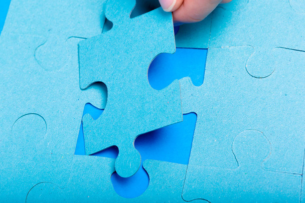close up of hand holding Puzzle piece on colorful background  - Zdjęcie, obraz